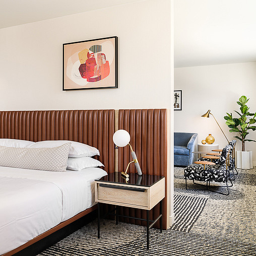 A bedroom with a bed and a chair.